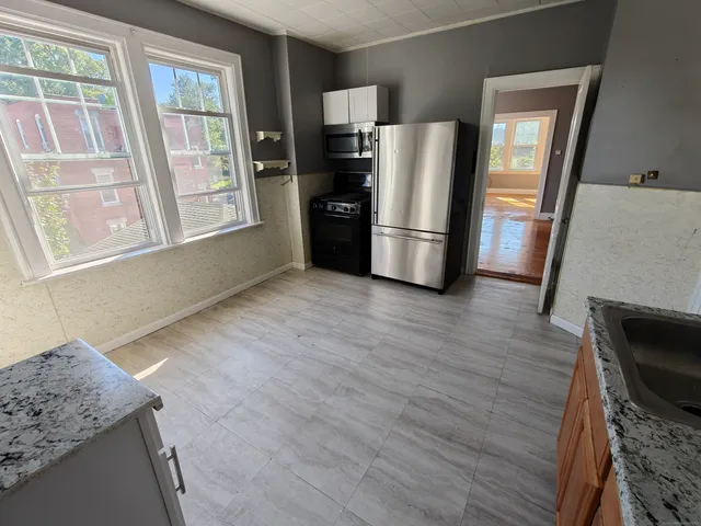 a view of a kitchen with wooden floor and electronic appliances