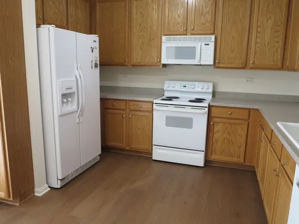 a kitchen with stainless steel appliances white cabinets and a refrigerator
