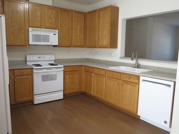 a kitchen with white cabinets sink and stove