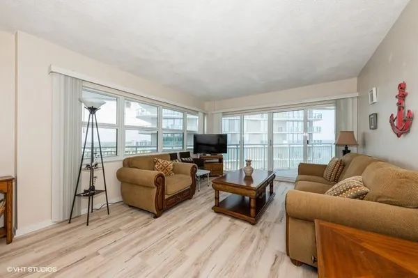 a living room with furniture flat screen tv and a large window