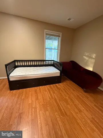 a room with a chair and white cabinets