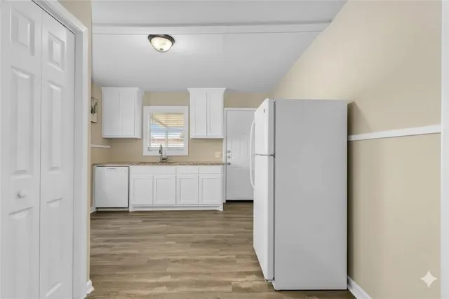 a kitchen with a refrigerator a sink and cabinets