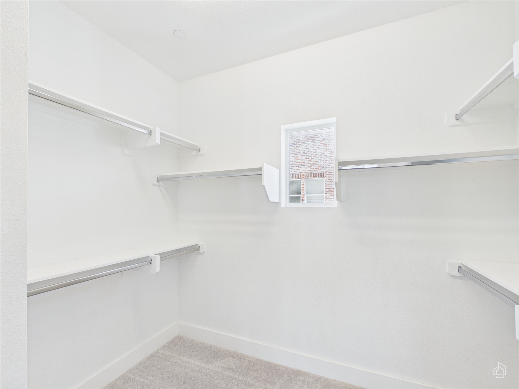 1308 Tinnin Ford Road, Unit 14 Austin, TX 78741 - Photo 33 of 40 Ample built-in shelving and hanging rods maximize space in this carpeted walk-in closet.