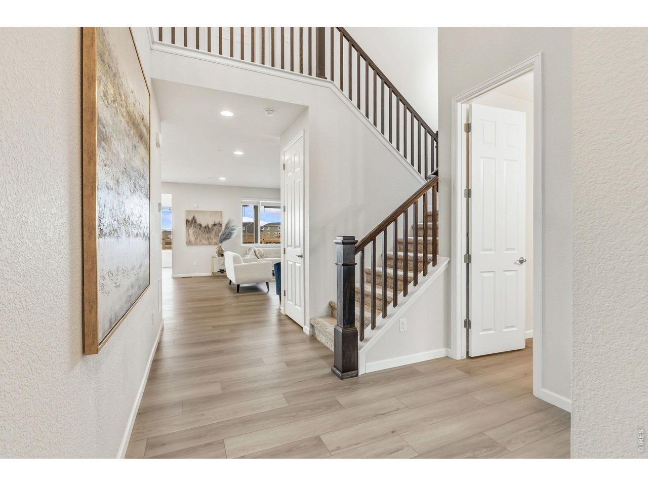 955 Rustling Street Windsor, CO 80550 - Photo 2 of 34 a view of a hallway with wooden floor windows and a living room