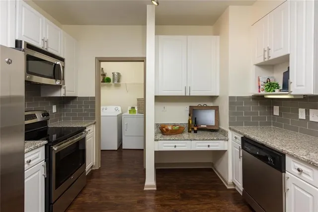 a kitchen with stainless steel appliances granite countertop a stove a sink and a microwave