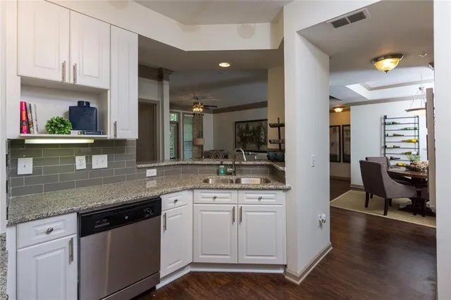a kitchen with granite countertop a sink stainless steel appliances and cabinets