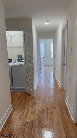 a view of hallway with wooden floor