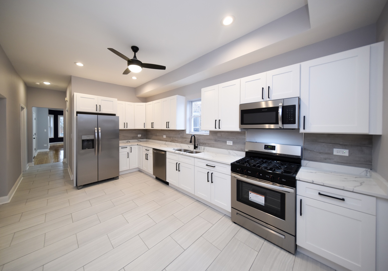 5932 South Elizabeth Street Chicago, IL 60636 - Photo 23 of 25 a large white kitchen with stainless steel appliances granite countertop a stove and a sink