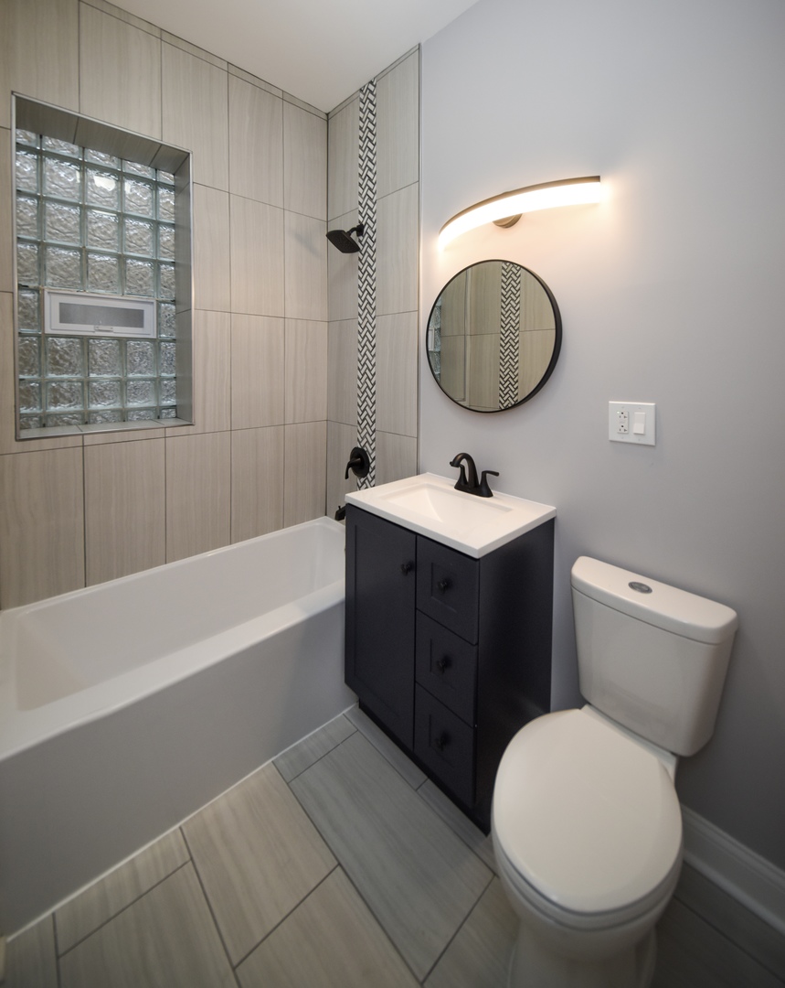 5932 South Elizabeth Street Chicago, IL 60636 - Photo 9 of 25 a bathroom with a toilet a sink and bathtub