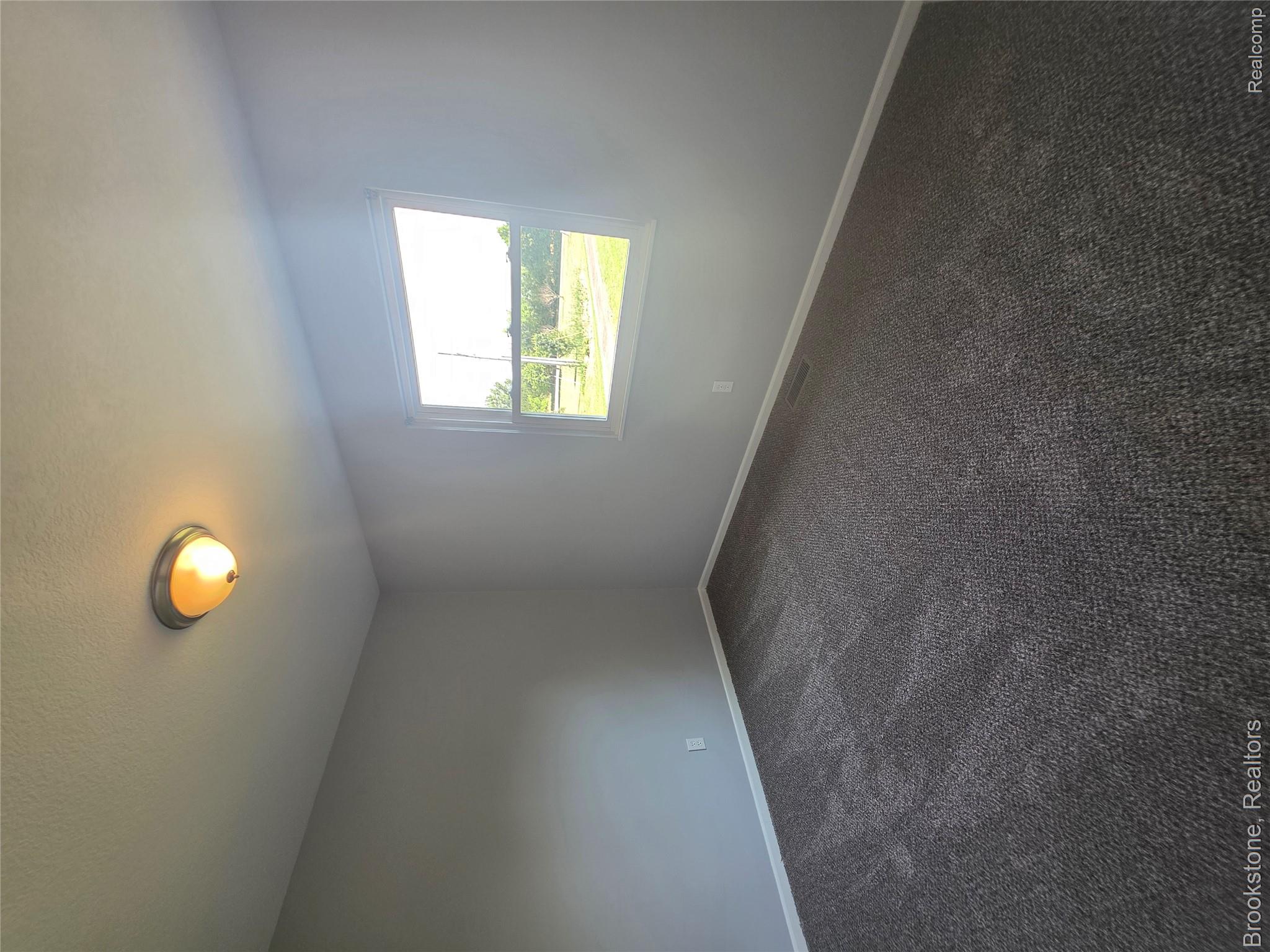 6428 Cook Road Swartz Creek, MI 48473 - Photo 10 of 12 Room featuring light gray walls, dark gray patterned carpeting, white baseboards, and a window with white trim