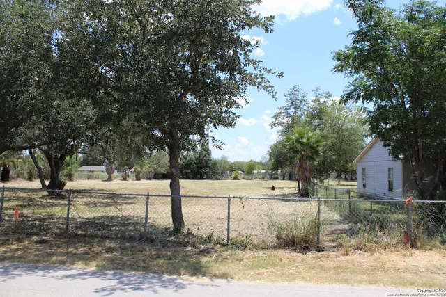 a view of a yard with wooden fence