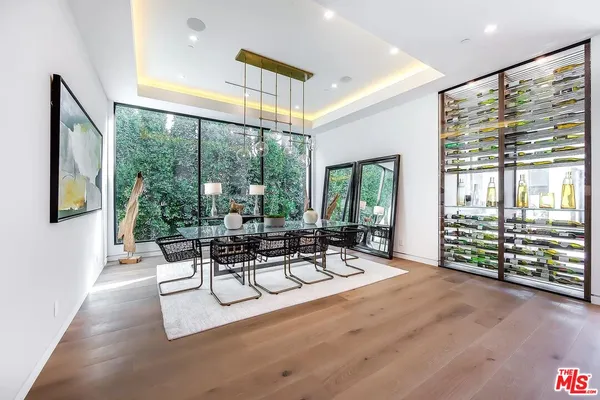 a view of a livingroom with furniture wooden floor and a floor to ceiling window