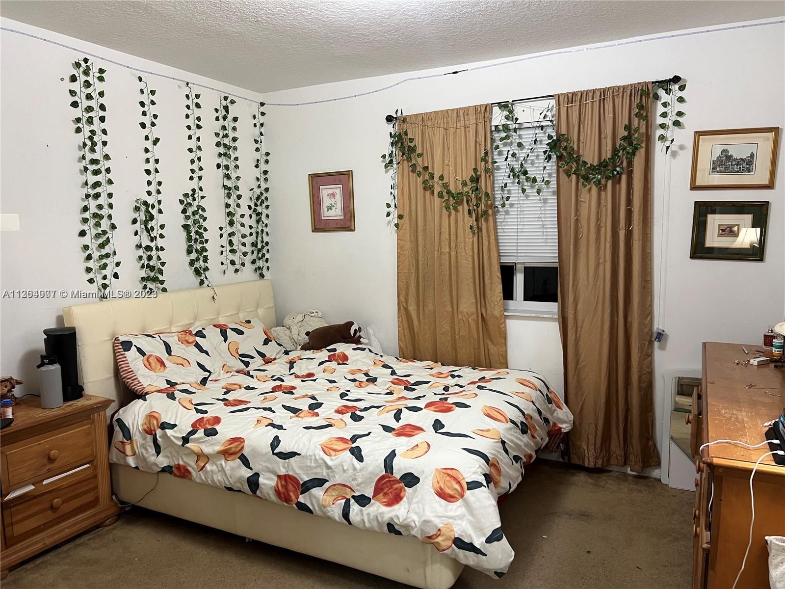 13974 Southwest 260th Street, Unit 102 Homestead, FL 33032 - Photo 12 of 16 a bedroom with a bed and a mirror