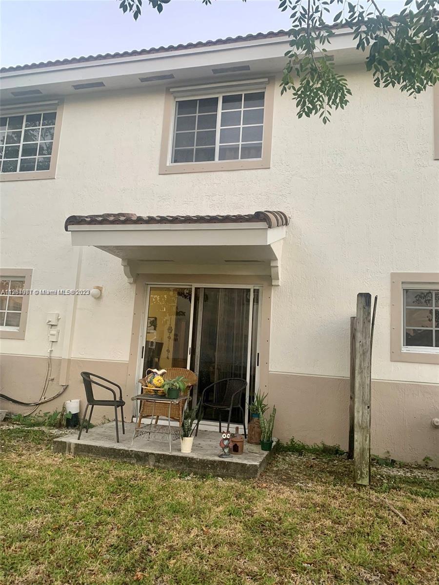 13974 Southwest 260th Street, Unit 102 Homestead, FL 33032 - Photo 13 of 16 a front view of a house with garden