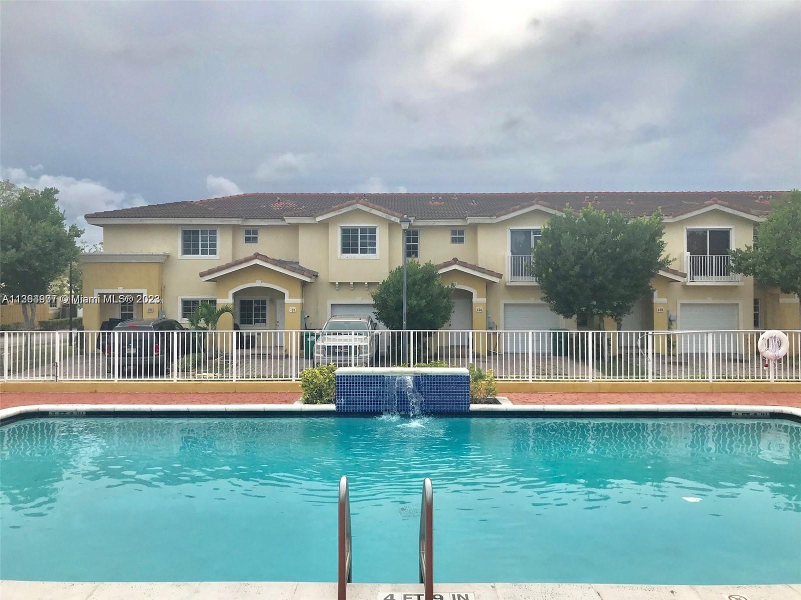 13974 Southwest 260th Street, Unit 102 Homestead, FL 33032 - Photo 15 of 16 front view of a house with a yard