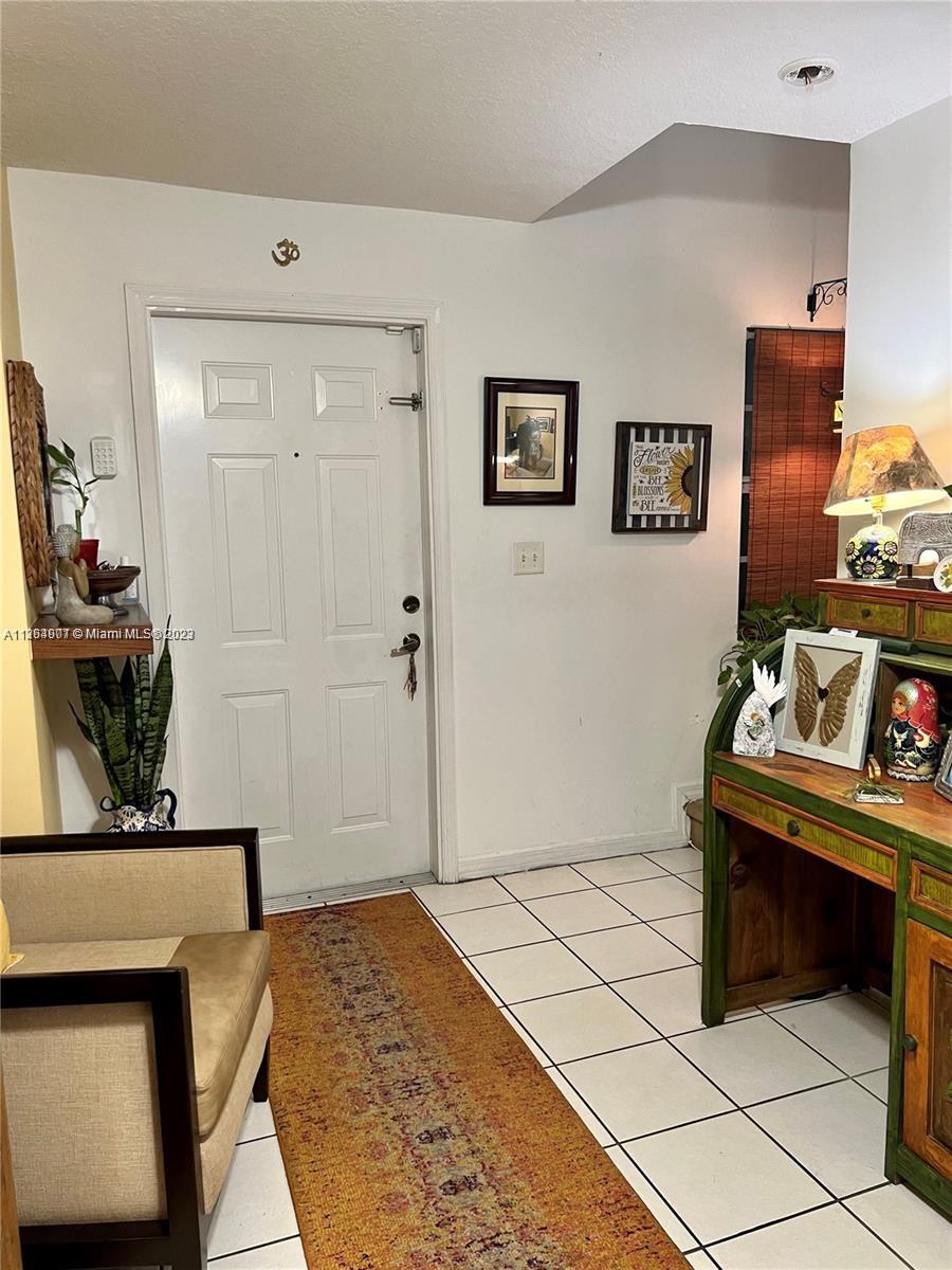 13974 Southwest 260th Street, Unit 102 Homestead, FL 33032 - Photo 2 of 16 a bedroom with a bed and a table in it