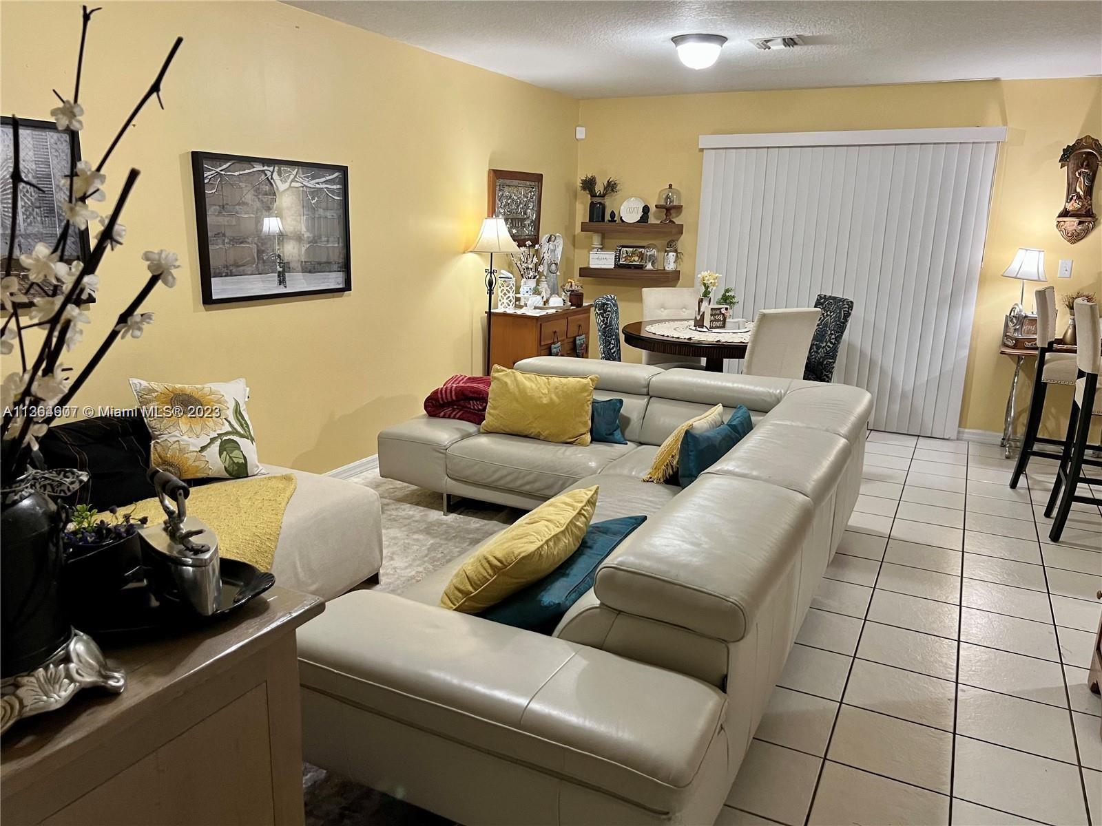 13974 Southwest 260th Street, Unit 102 Homestead, FL 33032 - Photo 3 of 16 a living room with furniture and a couch