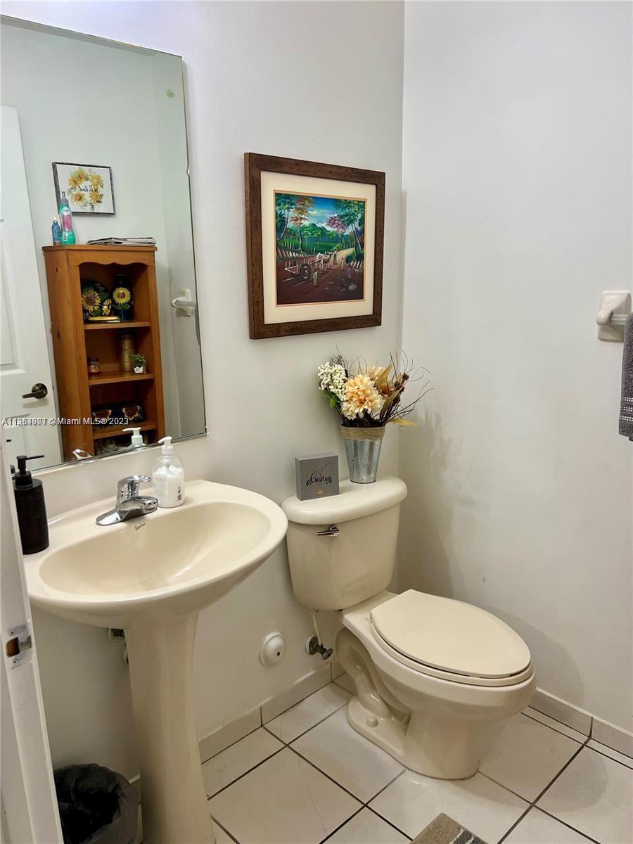 13974 Southwest 260th Street, Unit 102 Homestead, FL 33032 - Photo 5 of 16 a bathroom with a toilet a sink and mirror