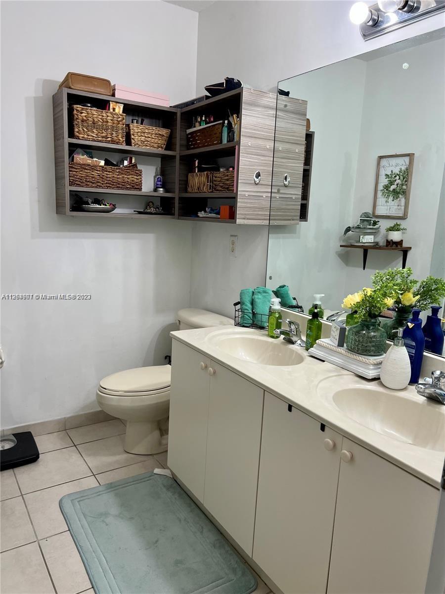 13974 Southwest 260th Street, Unit 102 Homestead, FL 33032 - Photo 8 of 16 a bathroom with a sink a toilet and mirror