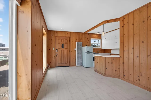 a view of a kitchen with refrigerator and wooden floor