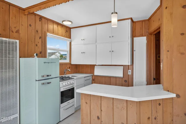 a kitchen that has a stove and a table in it