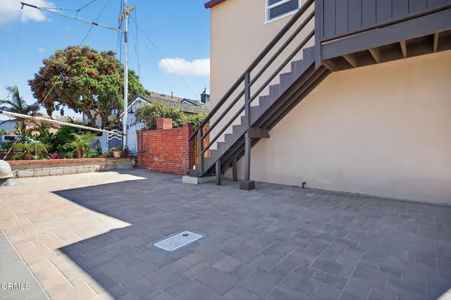a backyard of a house with large trees and plants