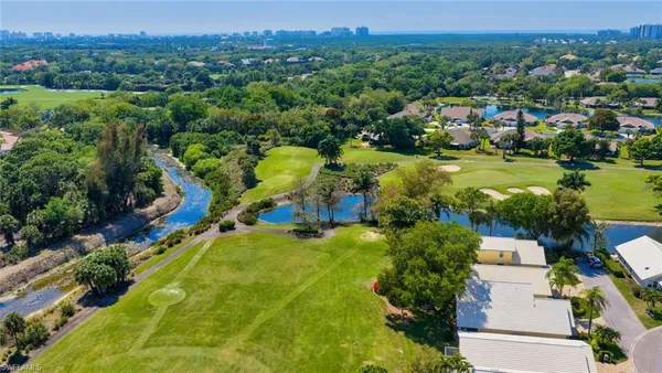 an aerial view of residential houses with outdoor space and trees