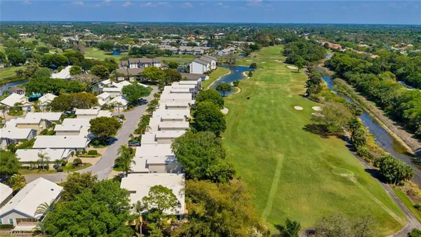 an aerial view of residential houses with outdoor space and trees