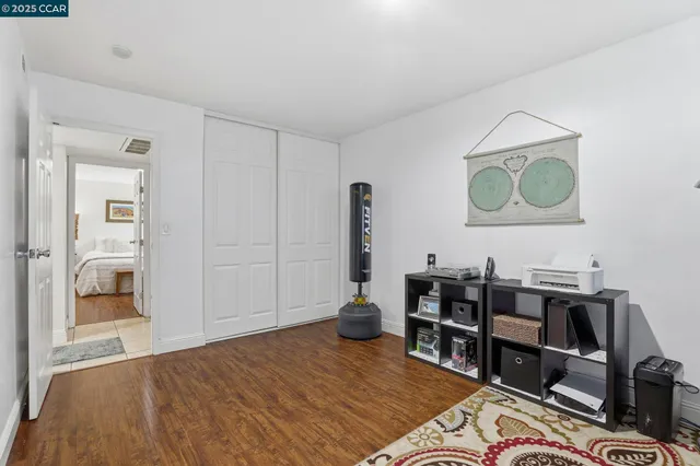 a bedroom with a bed and a painting on the wall