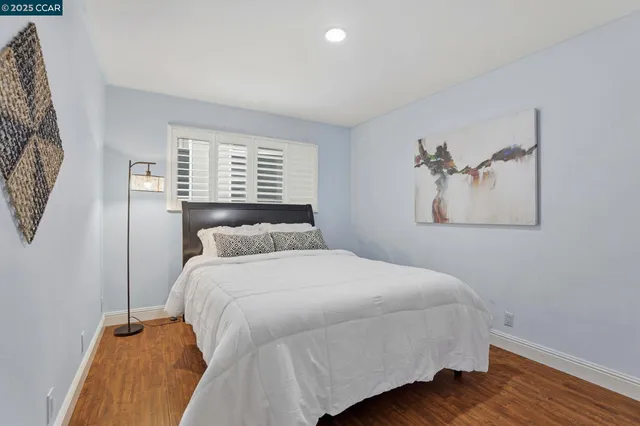 a bedroom with a bed and a painting on the wall