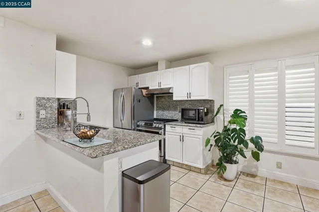 a white kitchen with cabinets and chairs