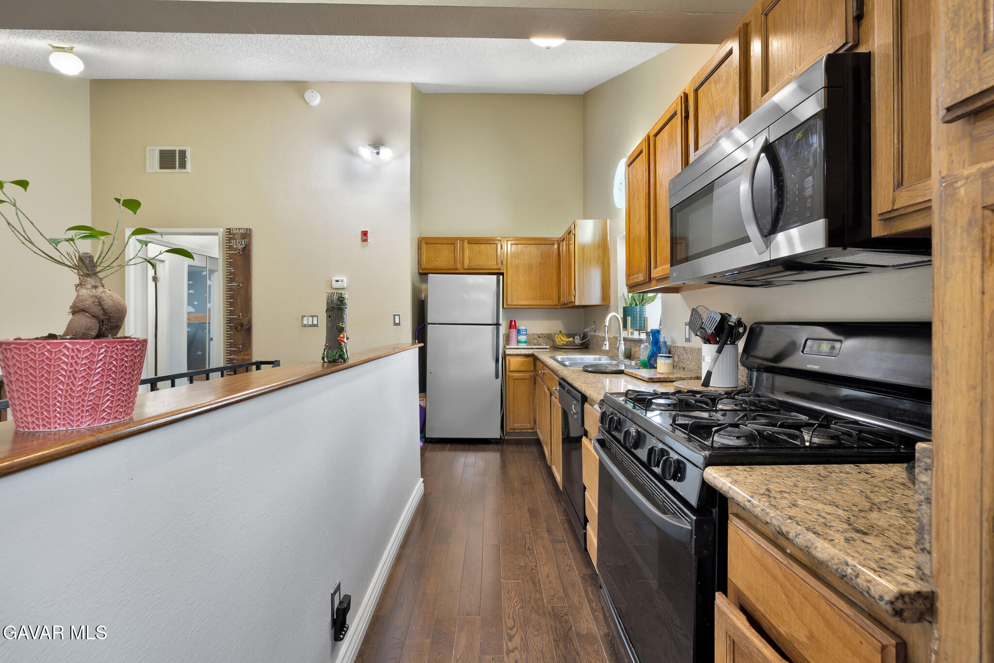14425 Foothill Boulevard, Unit 17 Sylmar, CA 91342 - Photo 8 of 27 a kitchen with stainless steel appliances a stove a sink and a refrigerator