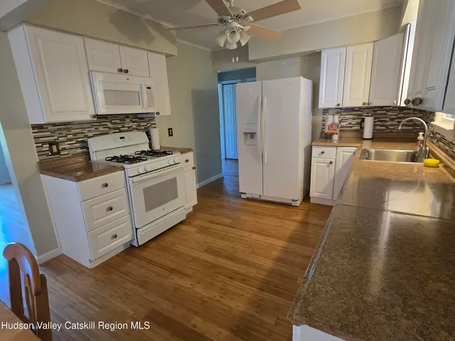 a kitchen with stainless steel appliances a stove a refrigerator a sink a counter space and cabinets