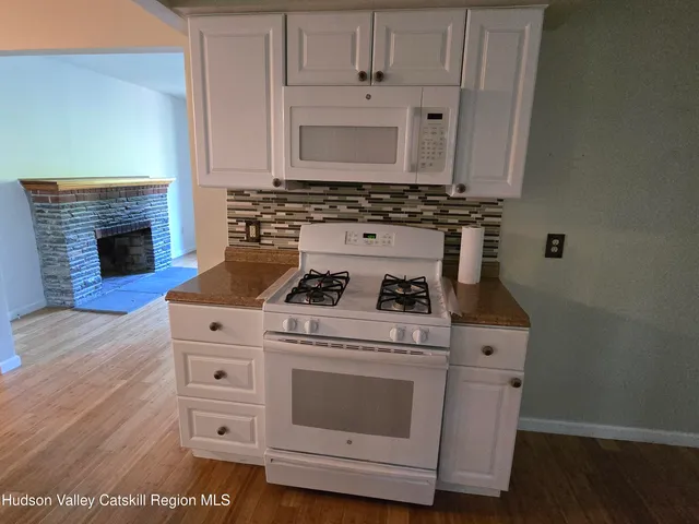 a white stove top oven sitting inside of a kitchen