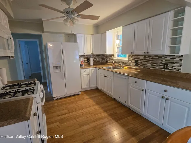 a kitchen with granite countertop a sink stainless steel appliances and cabinets