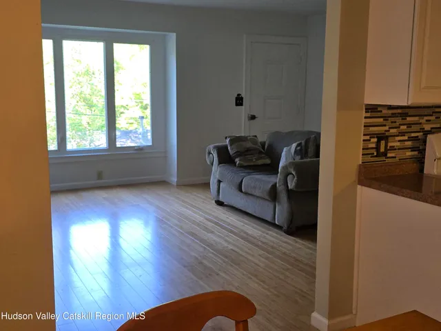 a living room with furniture wooden floor and a window