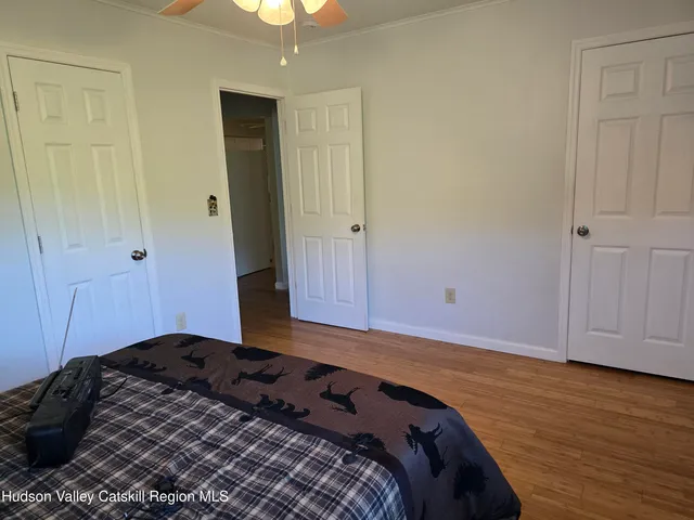 a bedroom with a bed and wooden floor