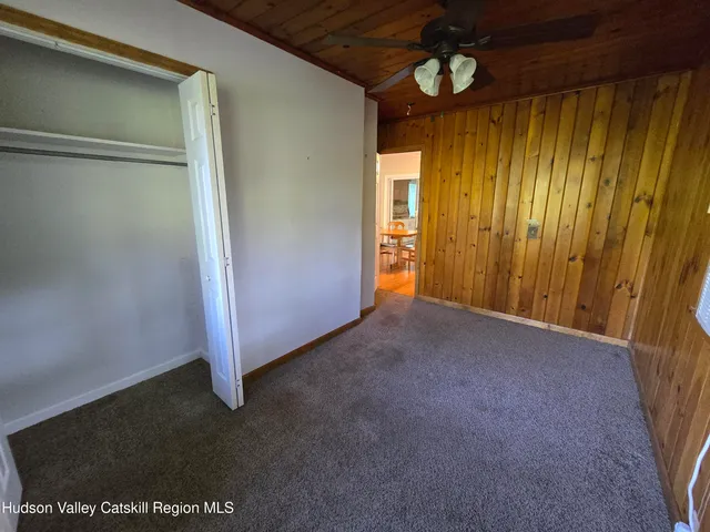 a view of a room that has a bed and wooden floor
