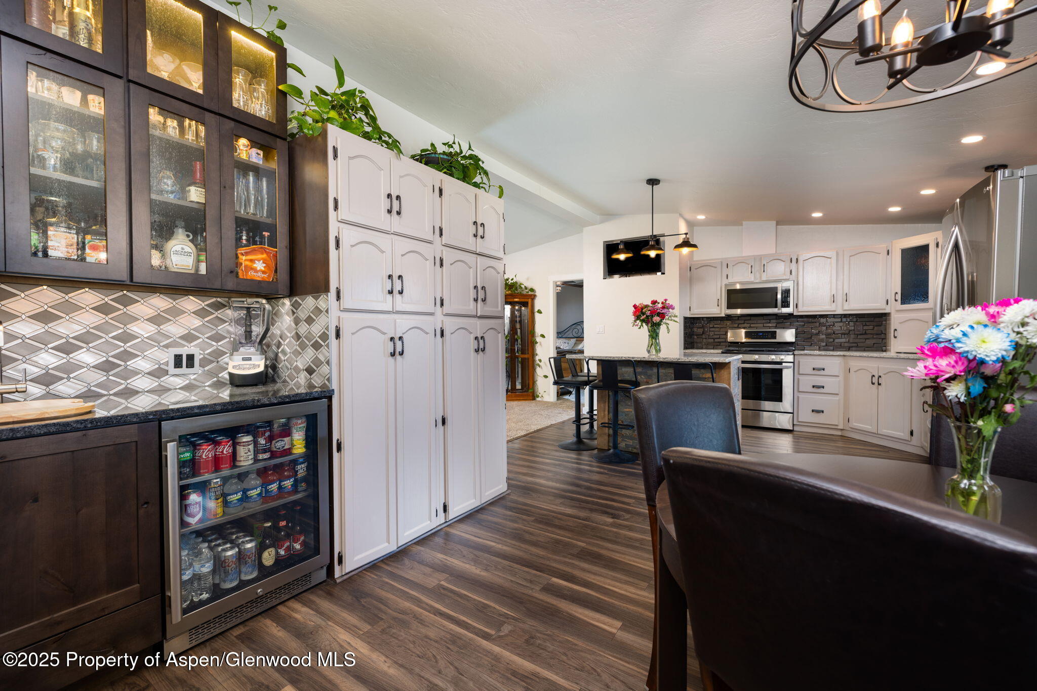 330 Will Avenue Rifle, CO 81650 - Photo 11 of 27 a kitchen with stainless steel appliances kitchen island granite countertop a refrigerator a stove top oven a dining table and chairs with wooden floor