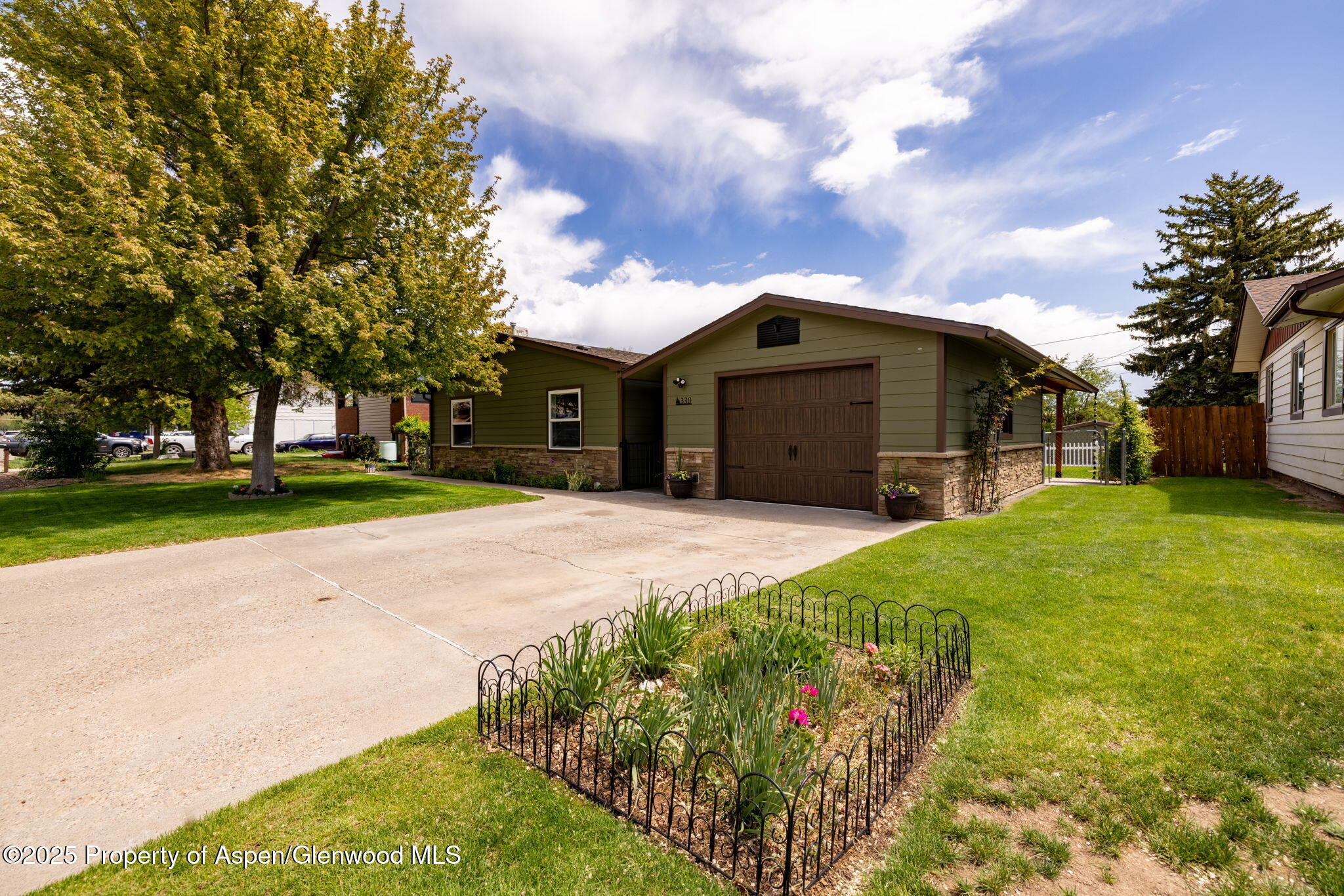 330 Will Avenue Rifle, CO 81650 - Photo 2 of 27 a front view of a house with a yard and garage