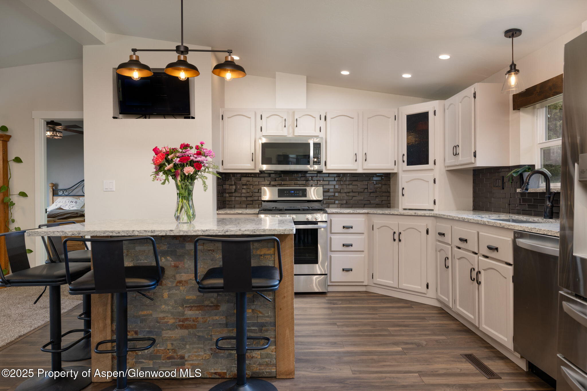 330 Will Avenue Rifle, CO 81650 - Photo 8 of 27 a kitchen with granite countertop a stove a microwave a dining table and chairs