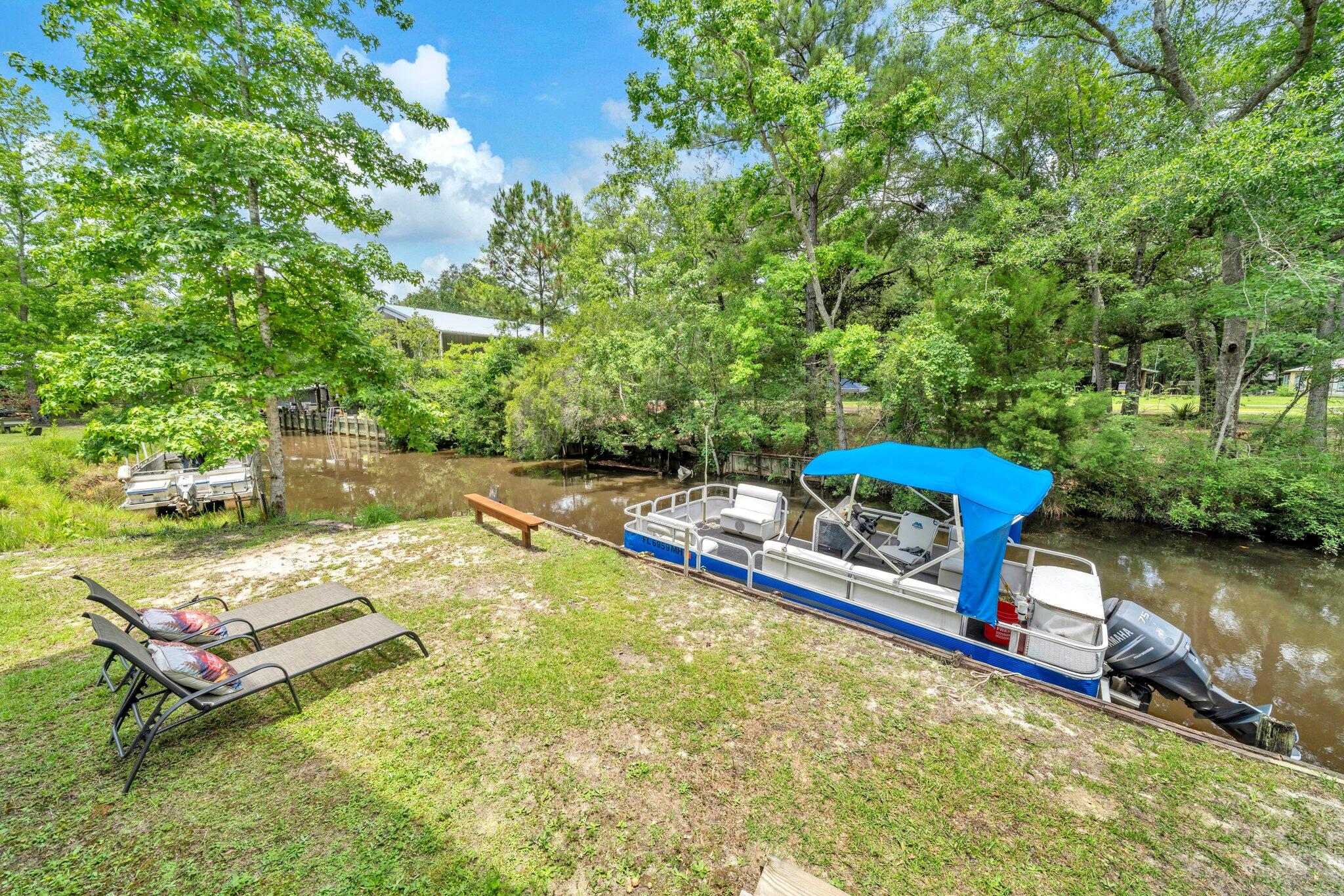 52 Lazy Bone St Point Vernon, FL 32462 - Photo 38 of 62 a view of a swimming pool with a bench and some trees