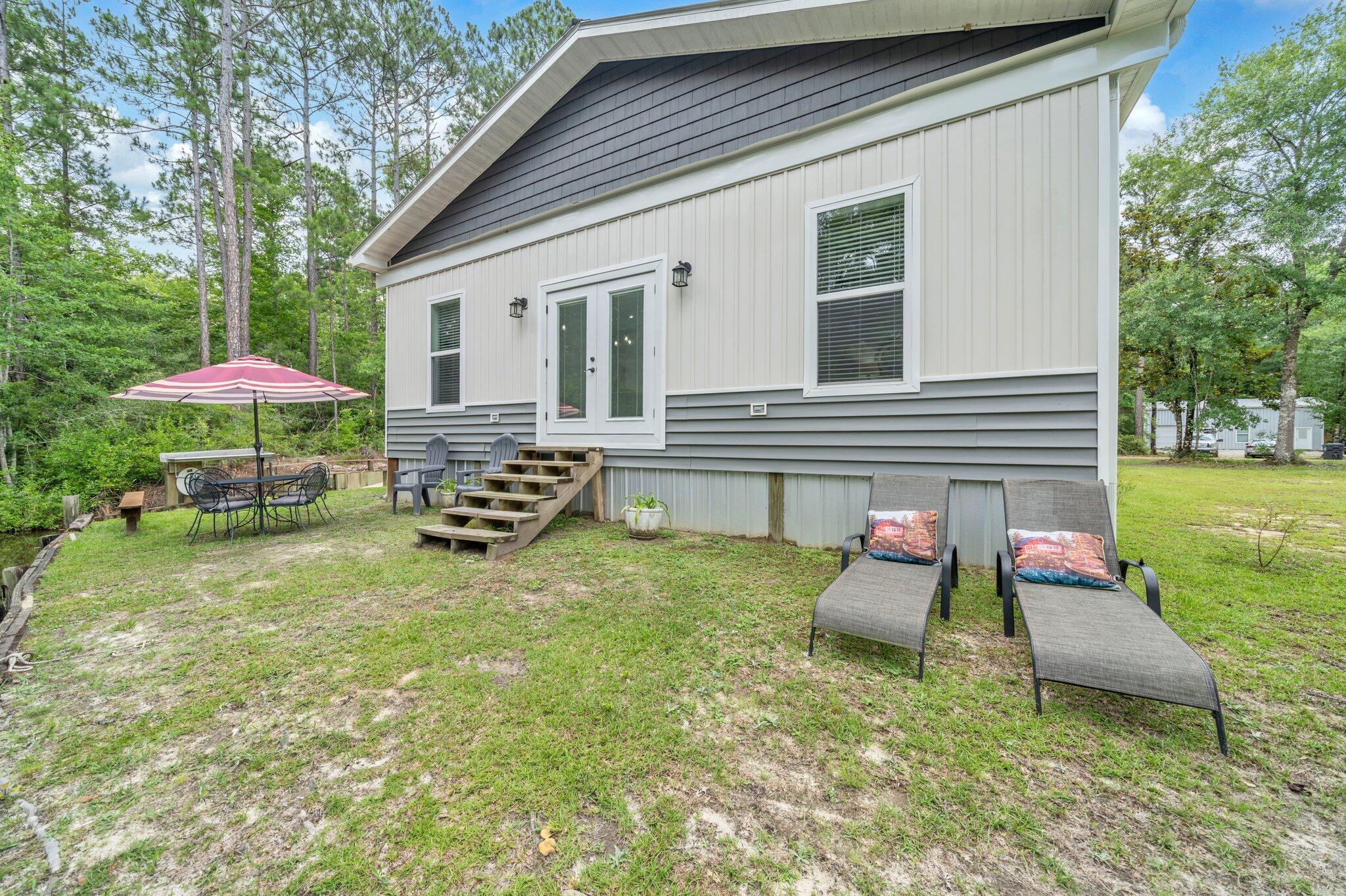 52 Lazy Bone St Point Vernon, FL 32462 - Photo 47 of 62 a backyard of a house with table and chairs