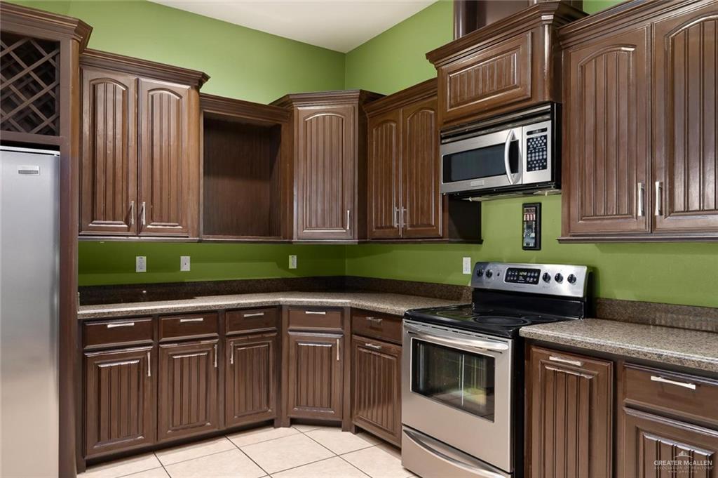 1910 West 41st Street Mission, TX 78573 - Photo 13 of 15 a kitchen with stainless steel appliances granite countertop a stove and a microwave
