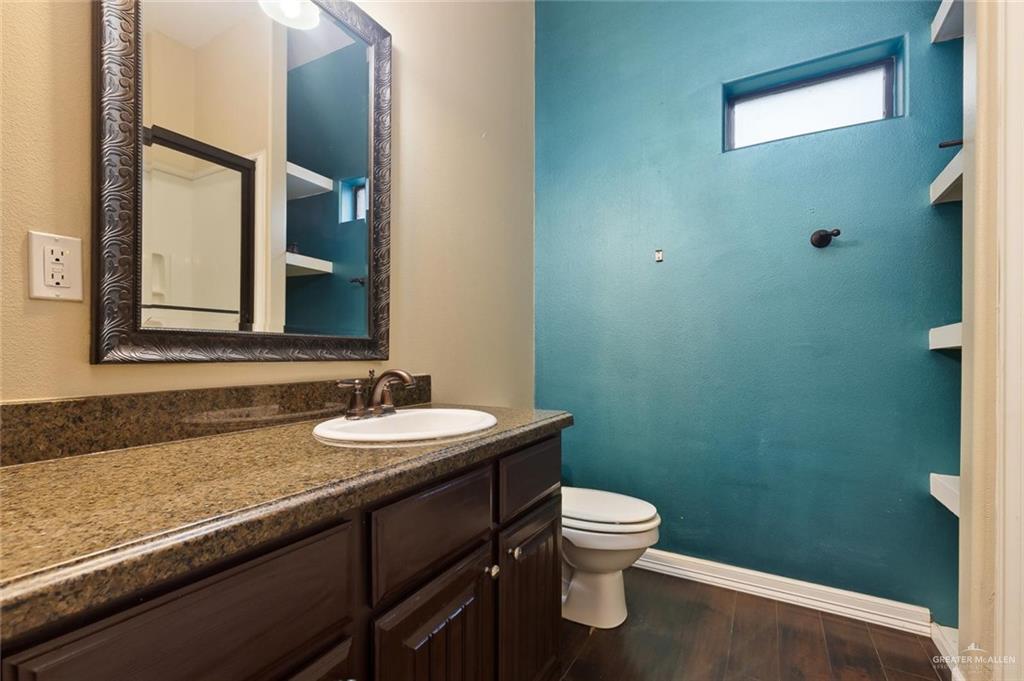 1910 West 41st Street Mission, TX 78573 - Photo 8 of 15 a bathroom with a granite countertop toilet sink and mirror
