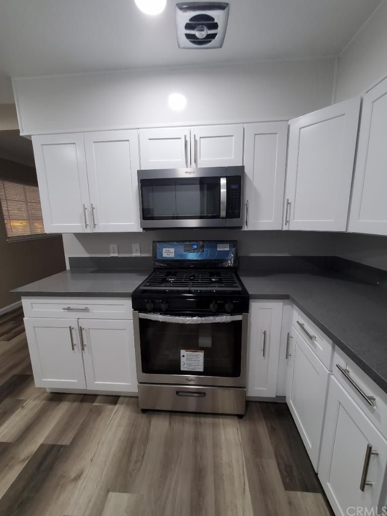 910 West Ave J8 Lancaster, CA 93534 - Photo 6 of 24 a kitchen with granite countertop a stove and a microwave