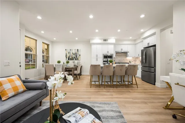 a living room with lots of furniture and a dining table with kitchen view