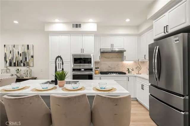 a kitchen with refrigerator a stove and cabinets