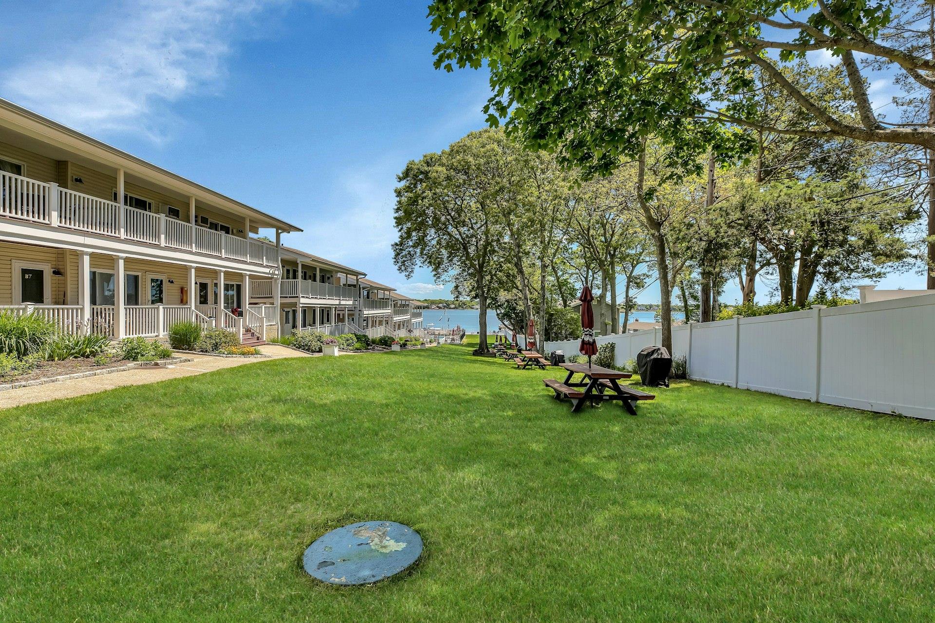 81 West Tiana Road, Unit B5 Hampton Bays, NY 11946 - Photo 1 of 1 Surrounding community with a yard, fence, and a water view