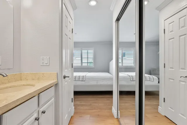 a en suite bathroom with a granite countertop sink and a mirror